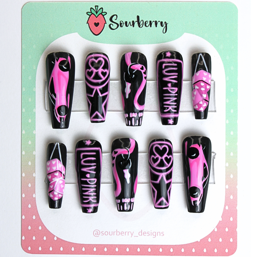 Step on the Gas nail set. The set is black and pink themed. The thumb nail has a racecar, the index nail has a neon design with hearts and starts, the middle nail has a car key and a speedometer, the ring nail has a neon license plate that says luv pink, and the pinky nail has fuzzy dice on them.