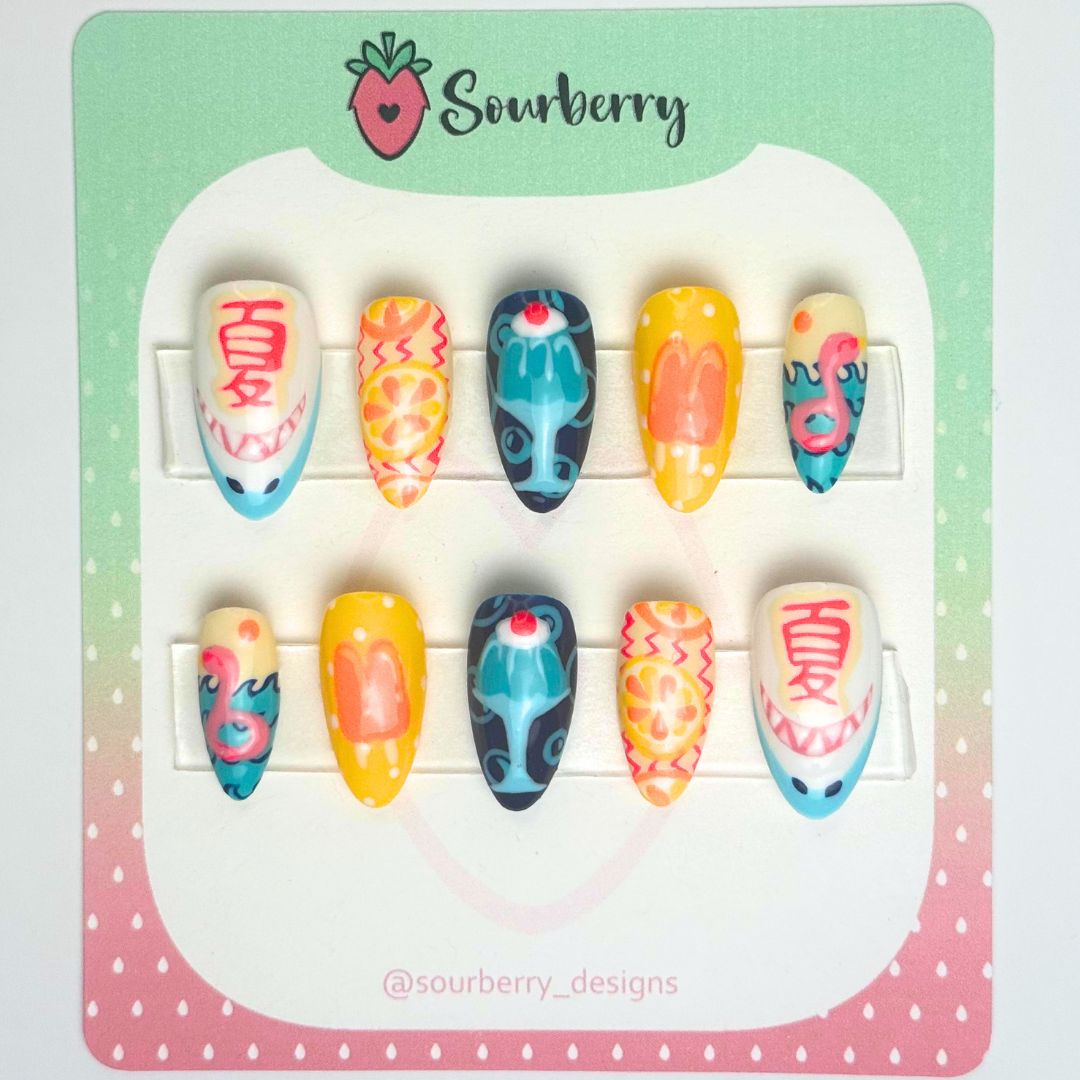 Sourberry brand beach bash nails. Thumb nail has a shark and the Japanese character for "summer" on it. The index nails have citrus fruits painted on them. The middle nails have a painting of a blue jello dessert. The ring nails have orange popsicles on them. The pinky nails have an ocean scene with a pink flamingo floatie.
